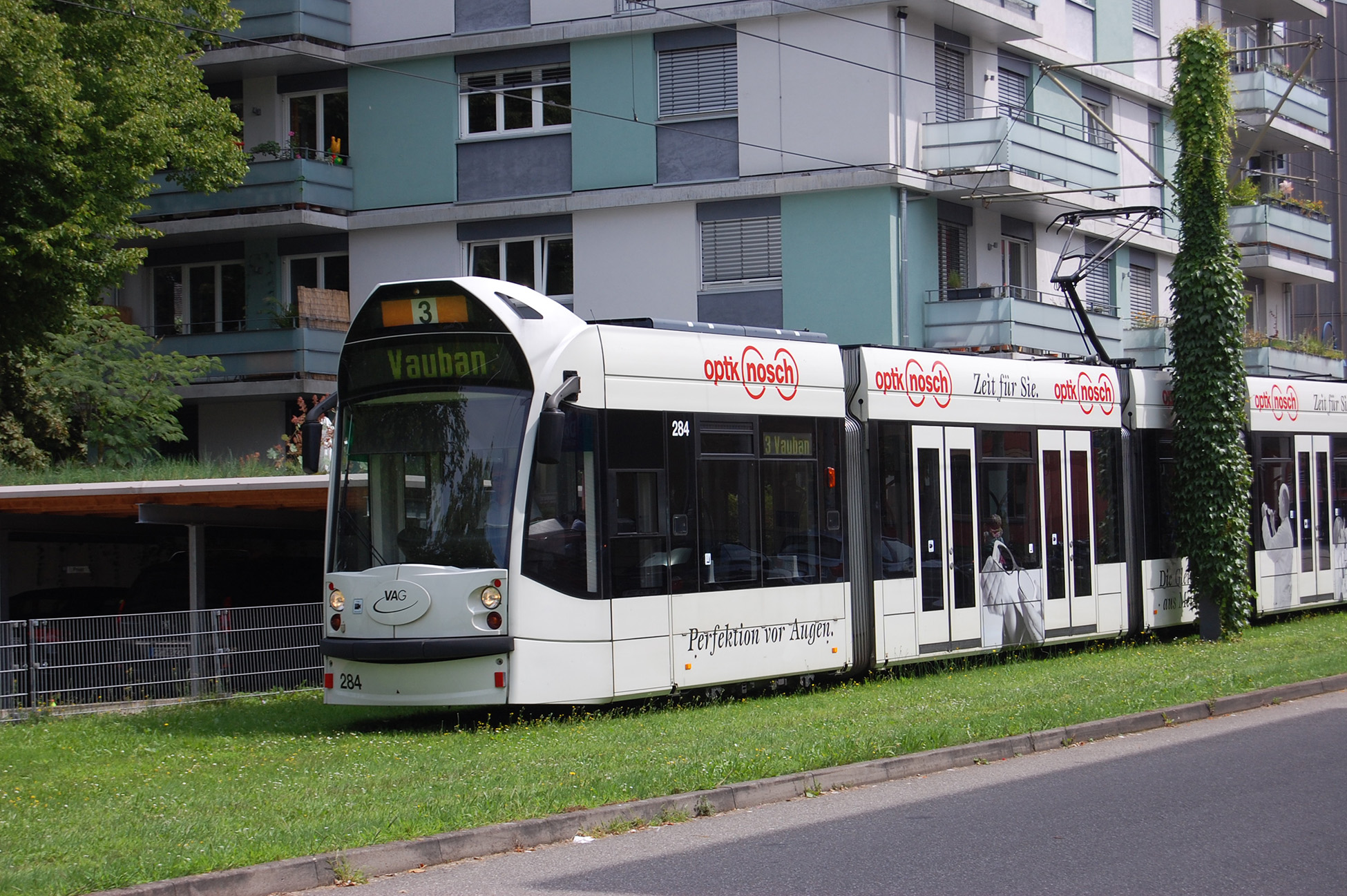 Modern trolley train passing apartments