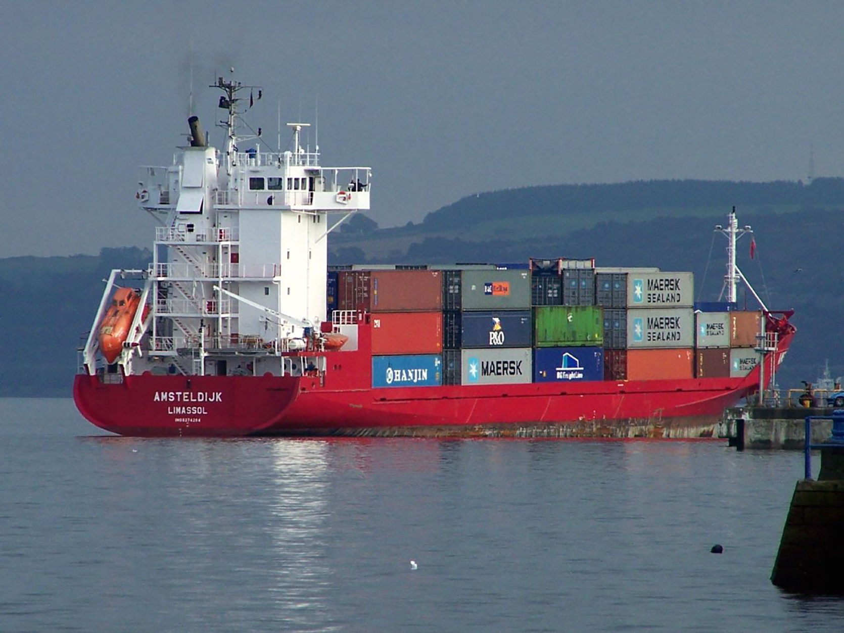 Large ship carrying rectangular shipping containers stacked three high