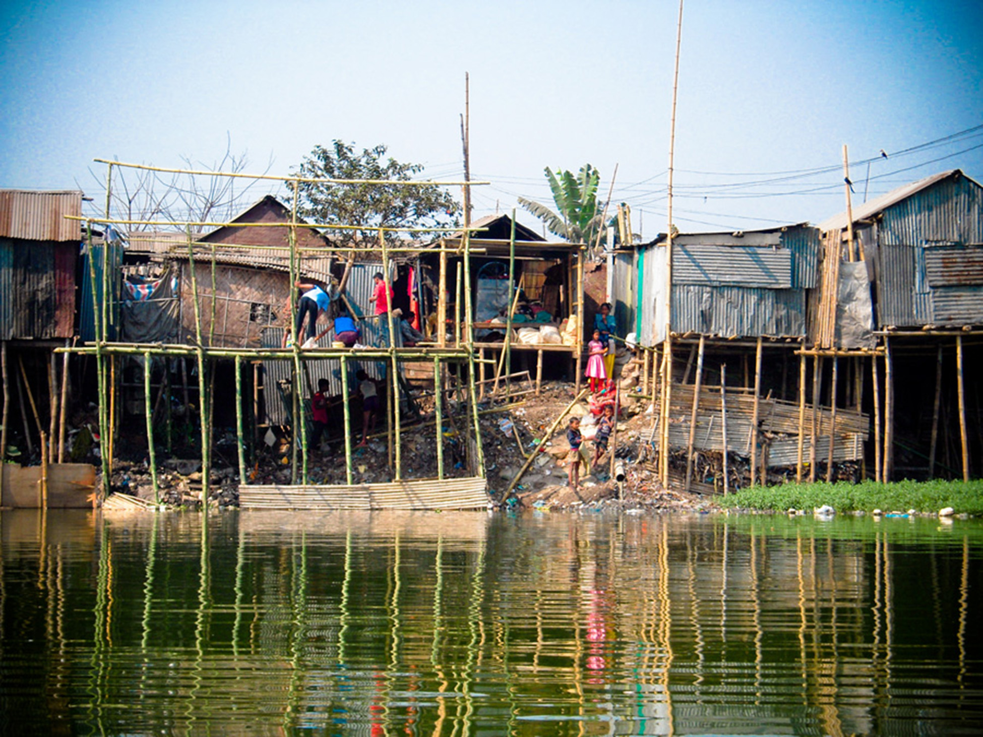 Row of houses being built on tall bamboo stilt structures.